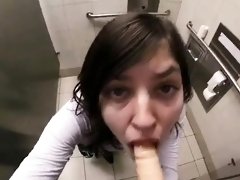 Naughty amateur teen deepthroats a dildo in a public toilet